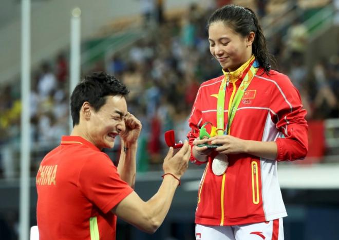 2016 Rio Olympics - Diving - Women's 3m Springboard Victory Ceremony - Maria Lenk Aquatics Centre - Rio de Janeiro, Brazil - 14/08/2016. He Zi (CHN) of China recieves a marriage proposal from Olympic diver Qin Kai (CHN) of China after the medal ceremony. She accepted Qin's proposal. REUTERS/Stefan Wermuth