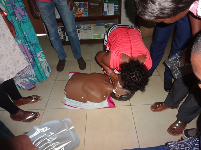 Programme Coordinator demonstrates CPR on an adult mannequin