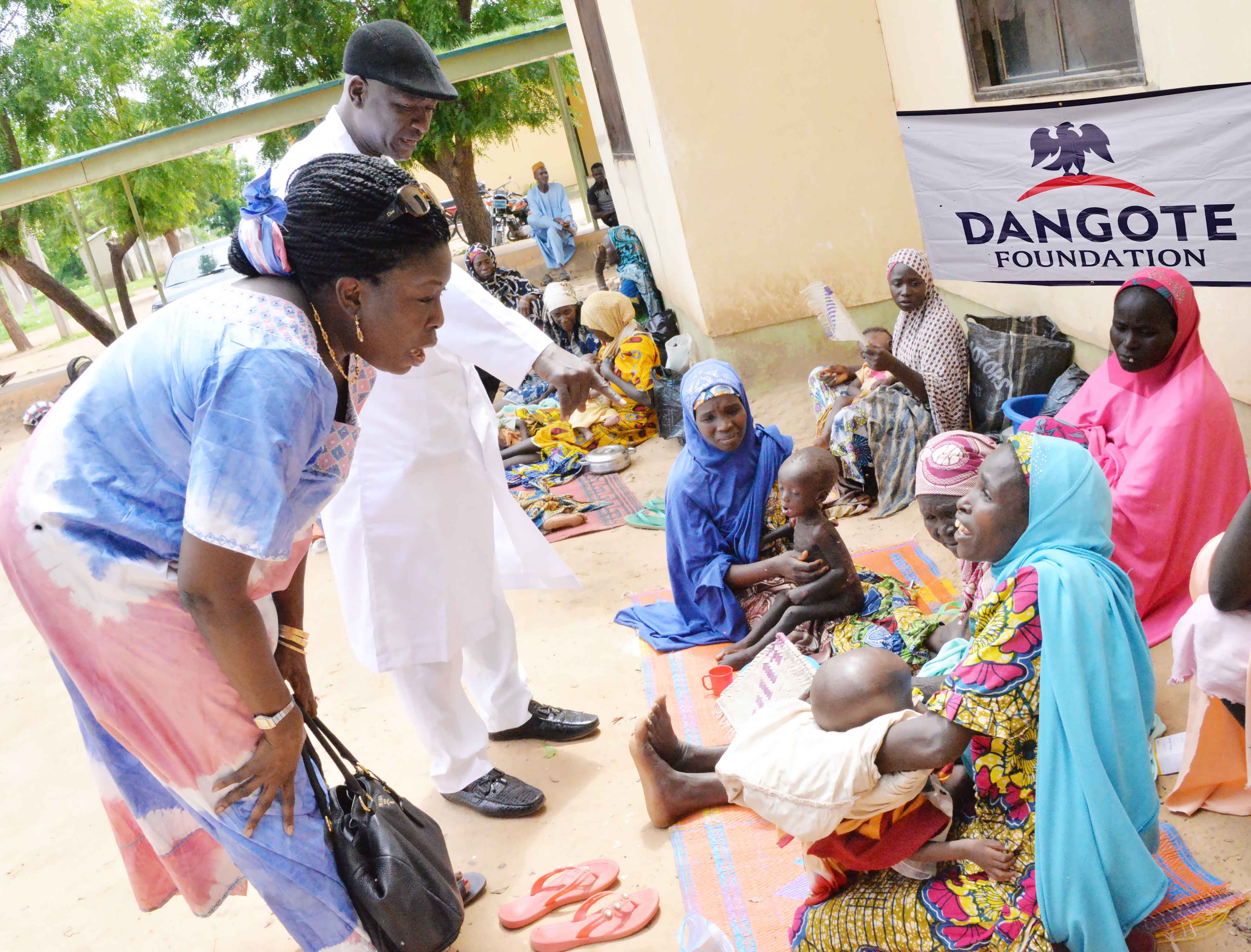Dangote Foundation,  Zouera Youssoufou with Project Leader, Central Bank Medical Services, Kano (North West), Dr. Tasiu Suleiman Gachi chatting with some beneficiaries  at Dangote Foundation sponsored community health outreach in Kankia L.G.A Katsina State