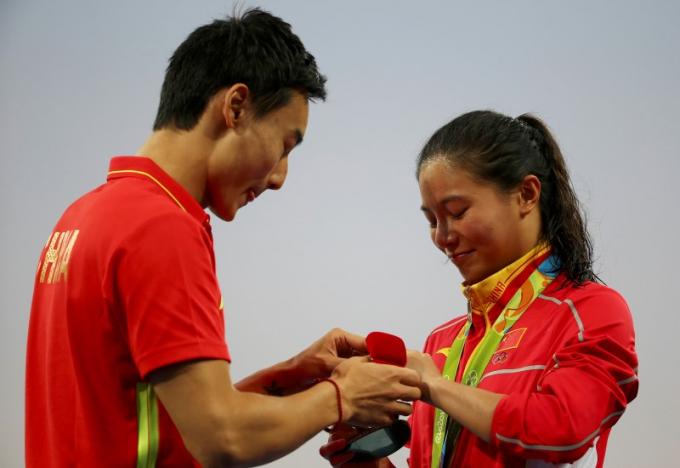 2016 Rio Olympics - Diving - Women's 3m Springboard Victory Ceremony - Maria Lenk Aquatics Centre - Rio de Janeiro, Brazil - 14/08/2016. He Zi (CHN) of China recieves a marriage proposal from Olympic diver Qin Kai (CHN) of China after the medal ceremony. She accepted Qin's proposal. REUTERS/Michael Dalder